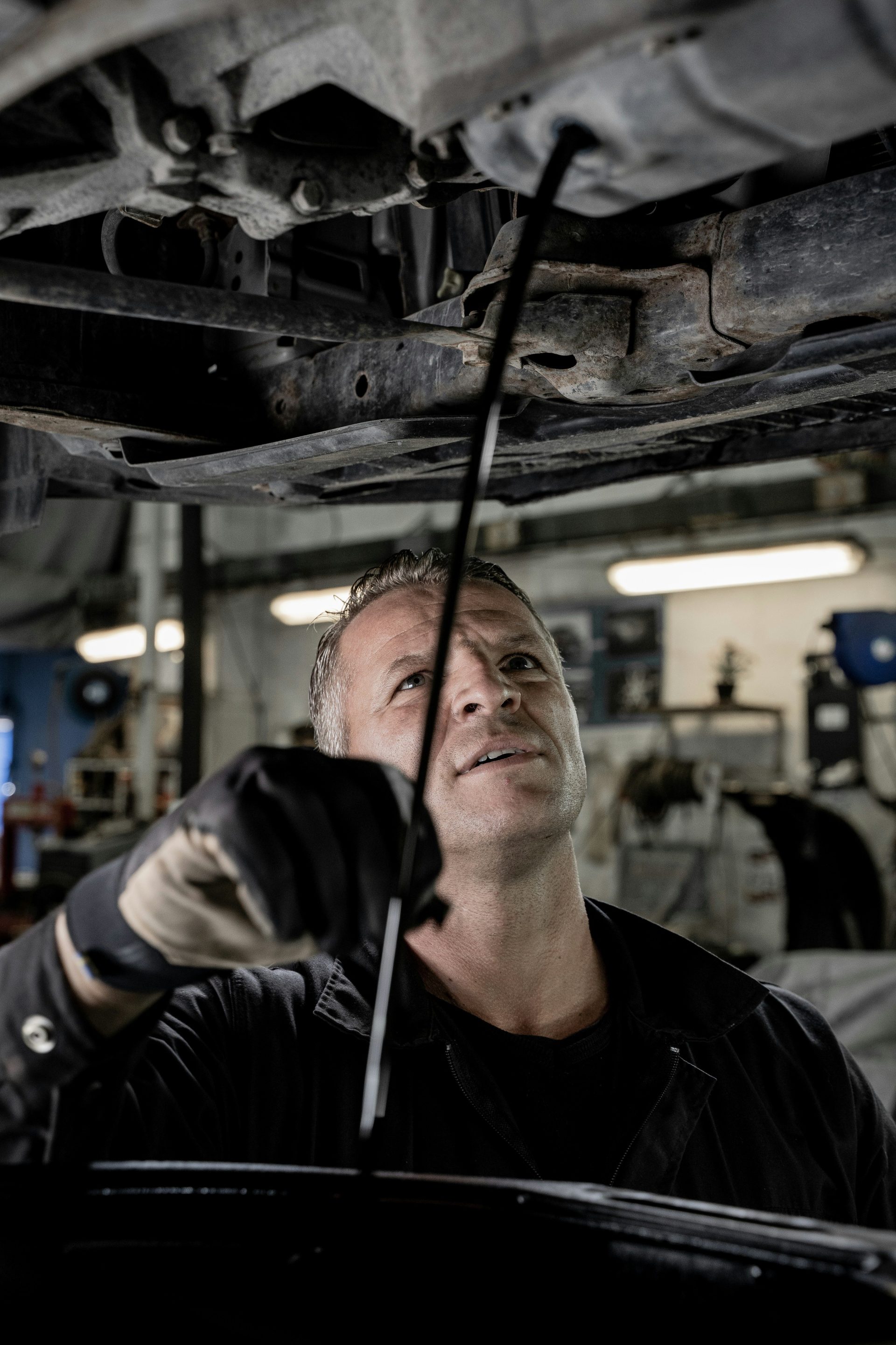 Ein Mann arbeitet in einer Garage an einem Auto.
